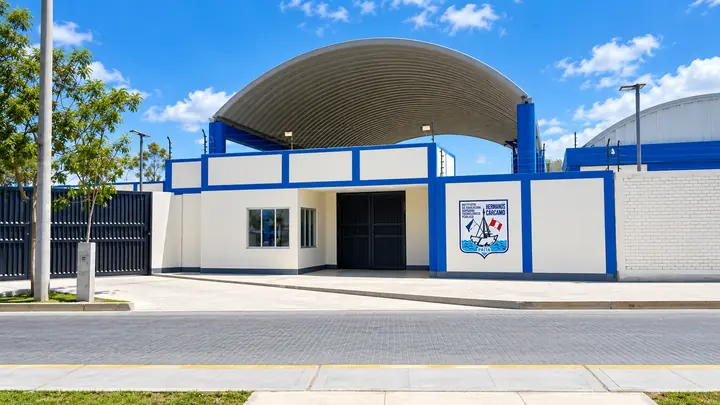 Fachada azul y blanca del IESTP Hermanos Cárcamo